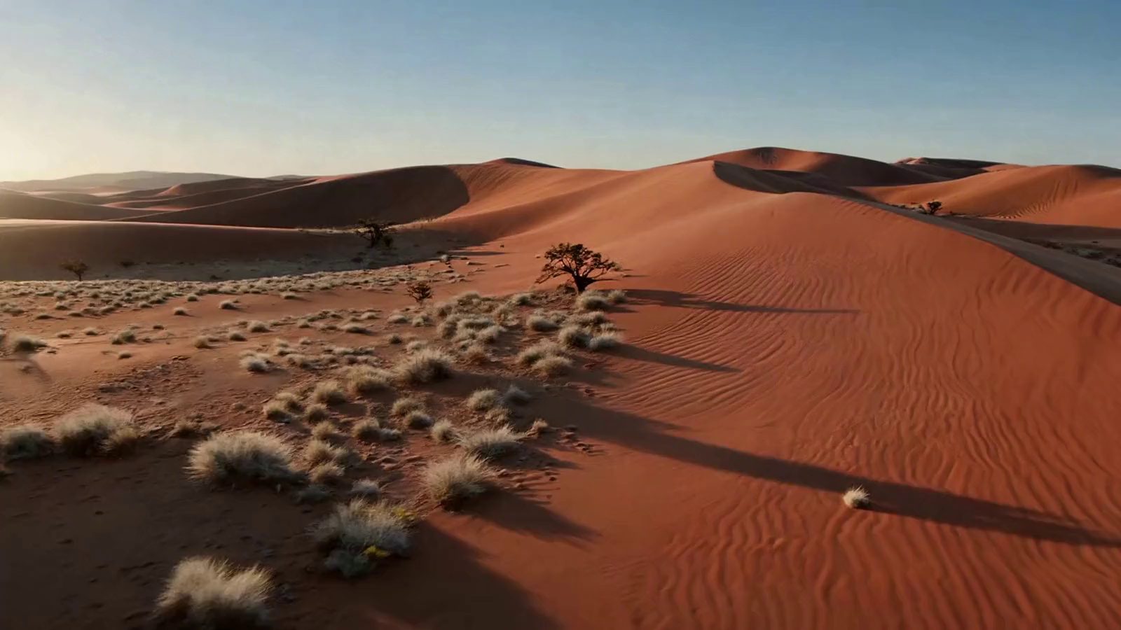 Red dune country from the air at first light — generated atmosphere, not a photograph of the route